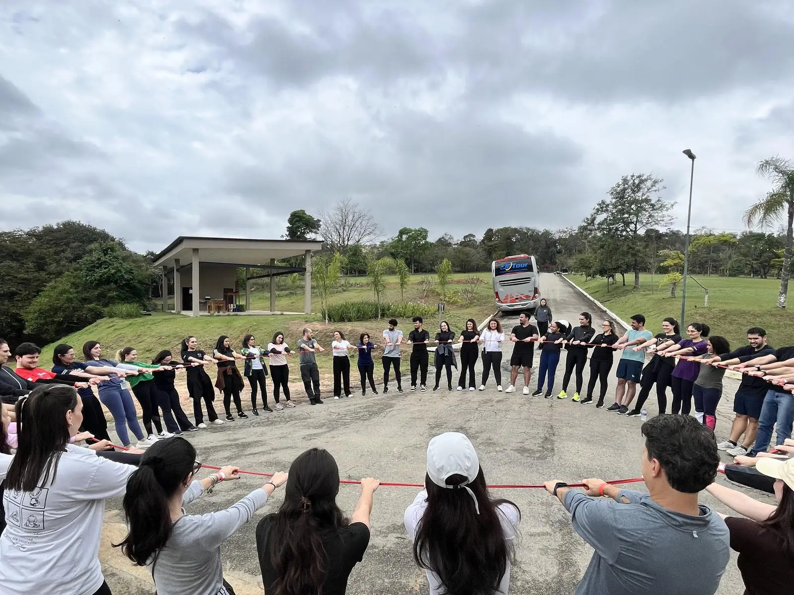 Grupo de 60 pessoas reunido em círculo ao ar livre no hotel fazenda em Itu